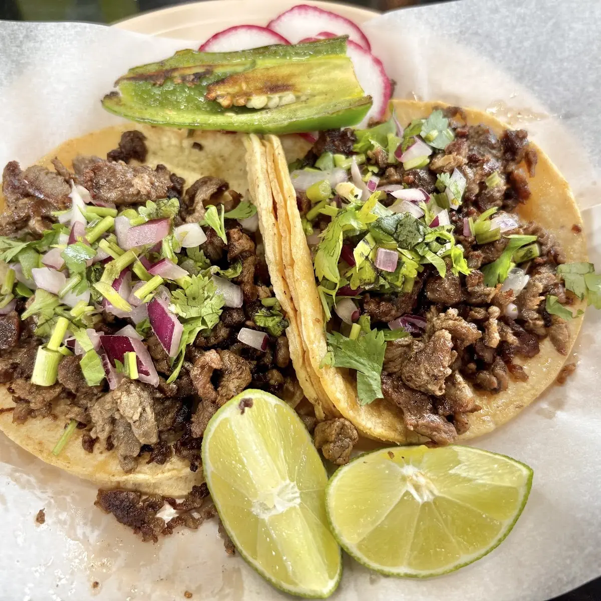 Two Steak Tacos with Lime Wedges