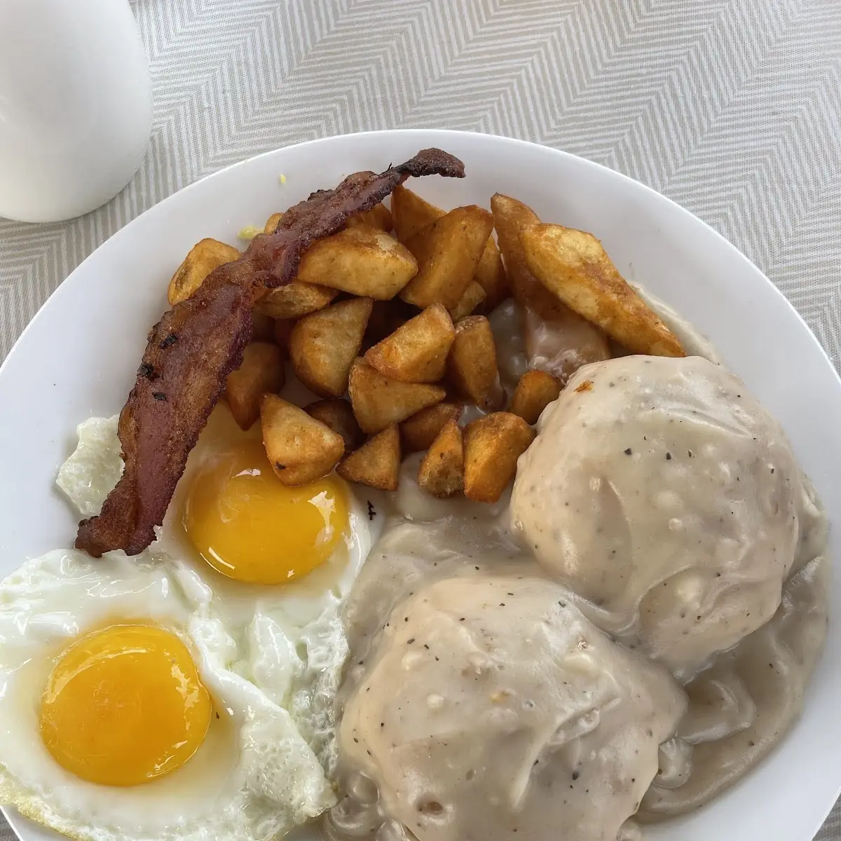 Biscuits and Gravy with Potatoes Bacon and Eggs Sunny Side Up