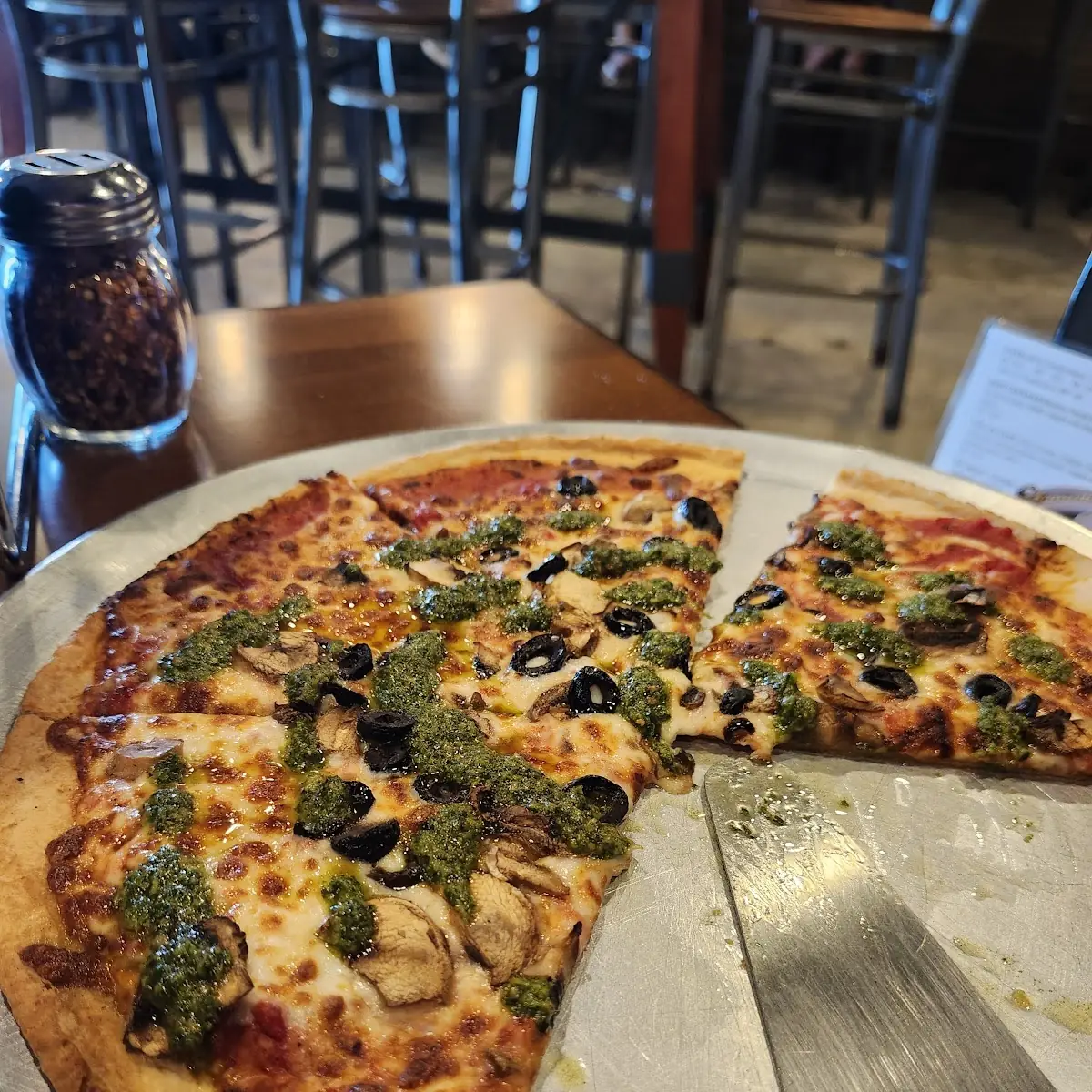 Basic Cheese Pizza with Added Mushrooms Black Olives and Pesto Drizzle