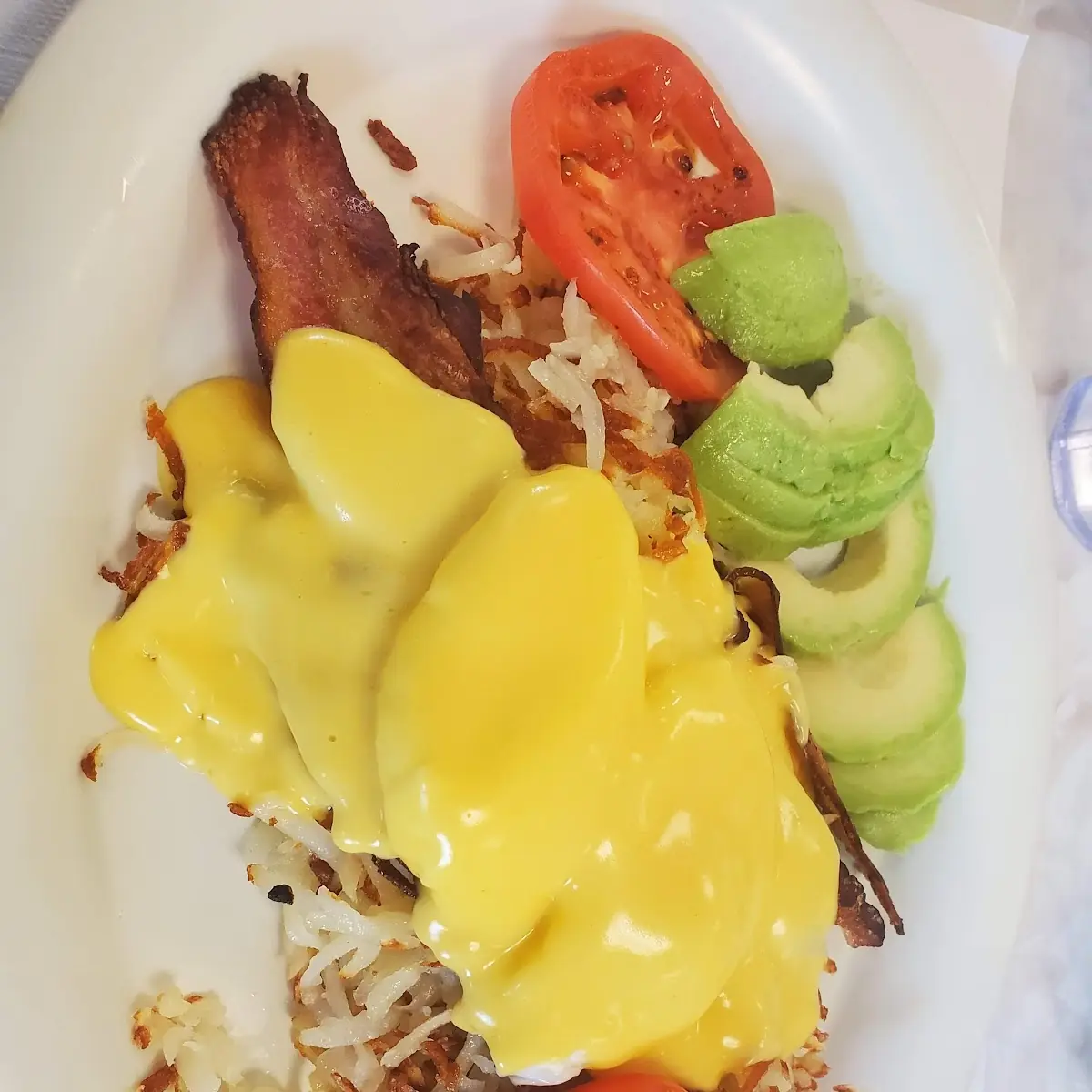 Eggs Benedict Bacon Hashbrowns and Fresh Avocado