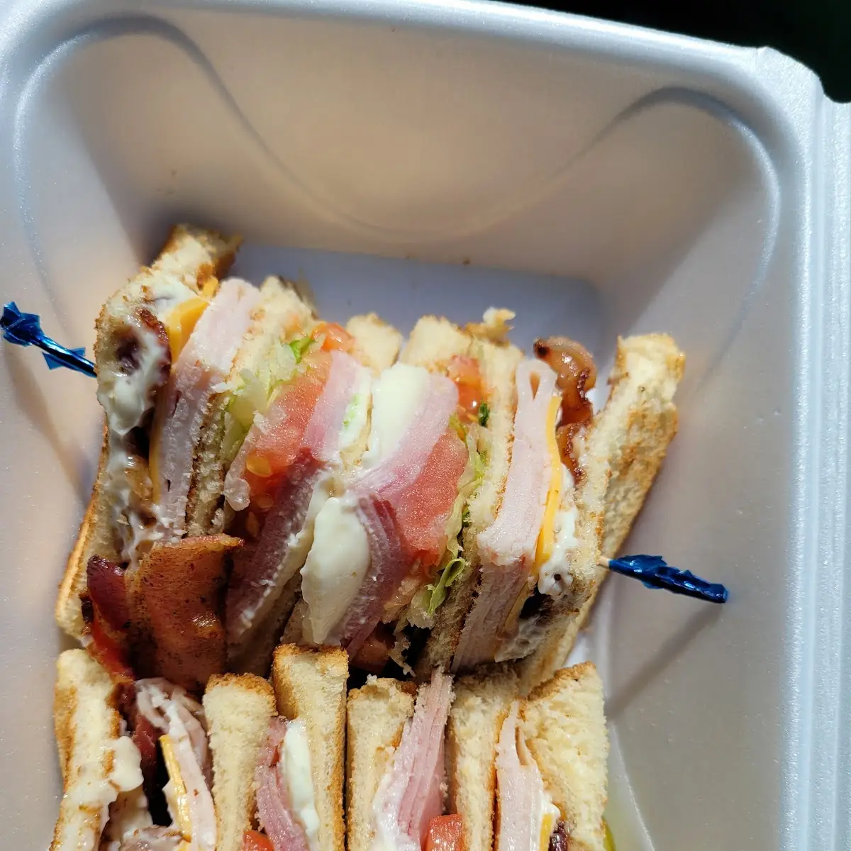 Three Decker Club with Ham Turkey Bacon Cheese Mayo Lettuce and Tomato and Three Slices of Bread