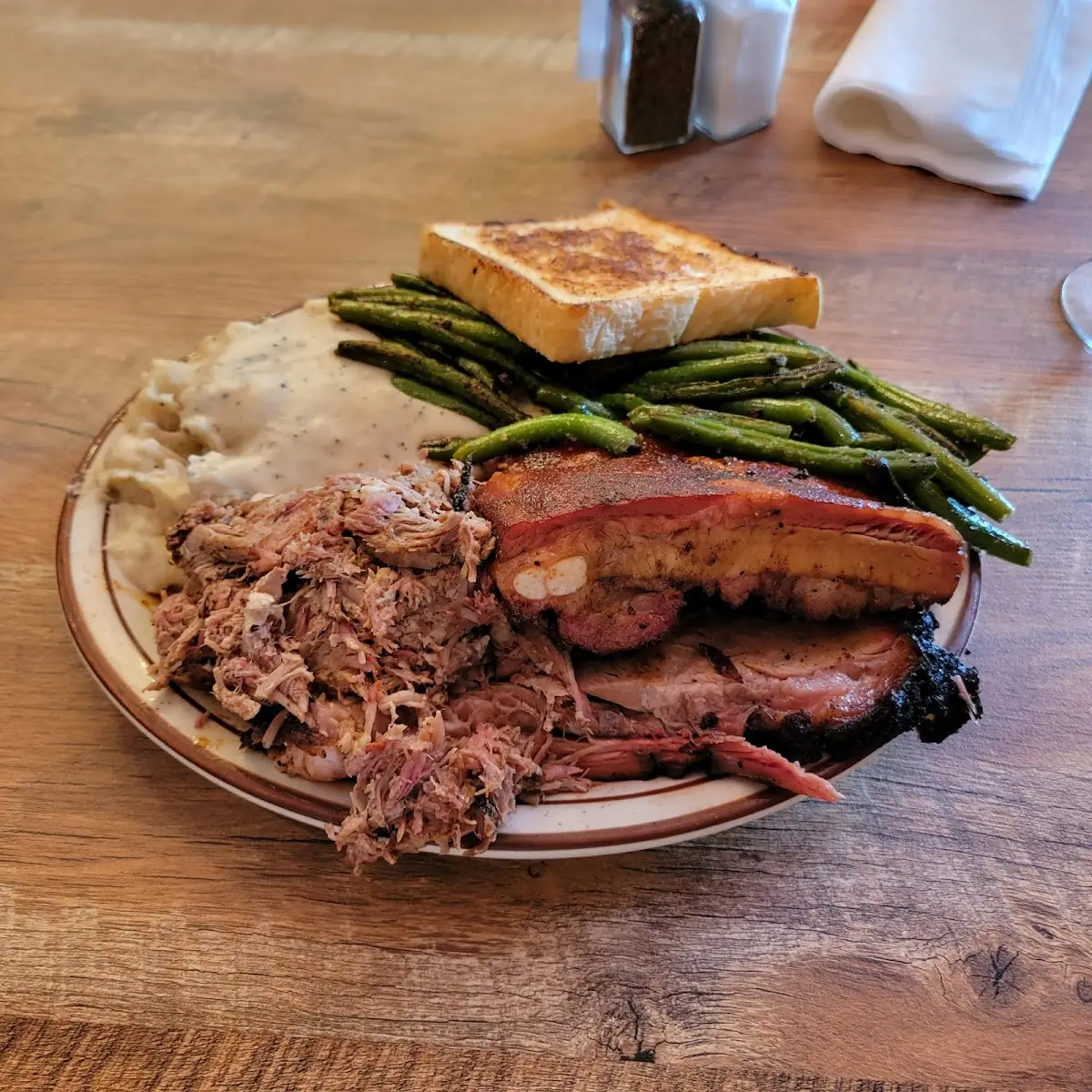 Sampler Plate with Ribs Brisket Pulled Pork Mashed Potatoes with Cream Gravy and Green Beans