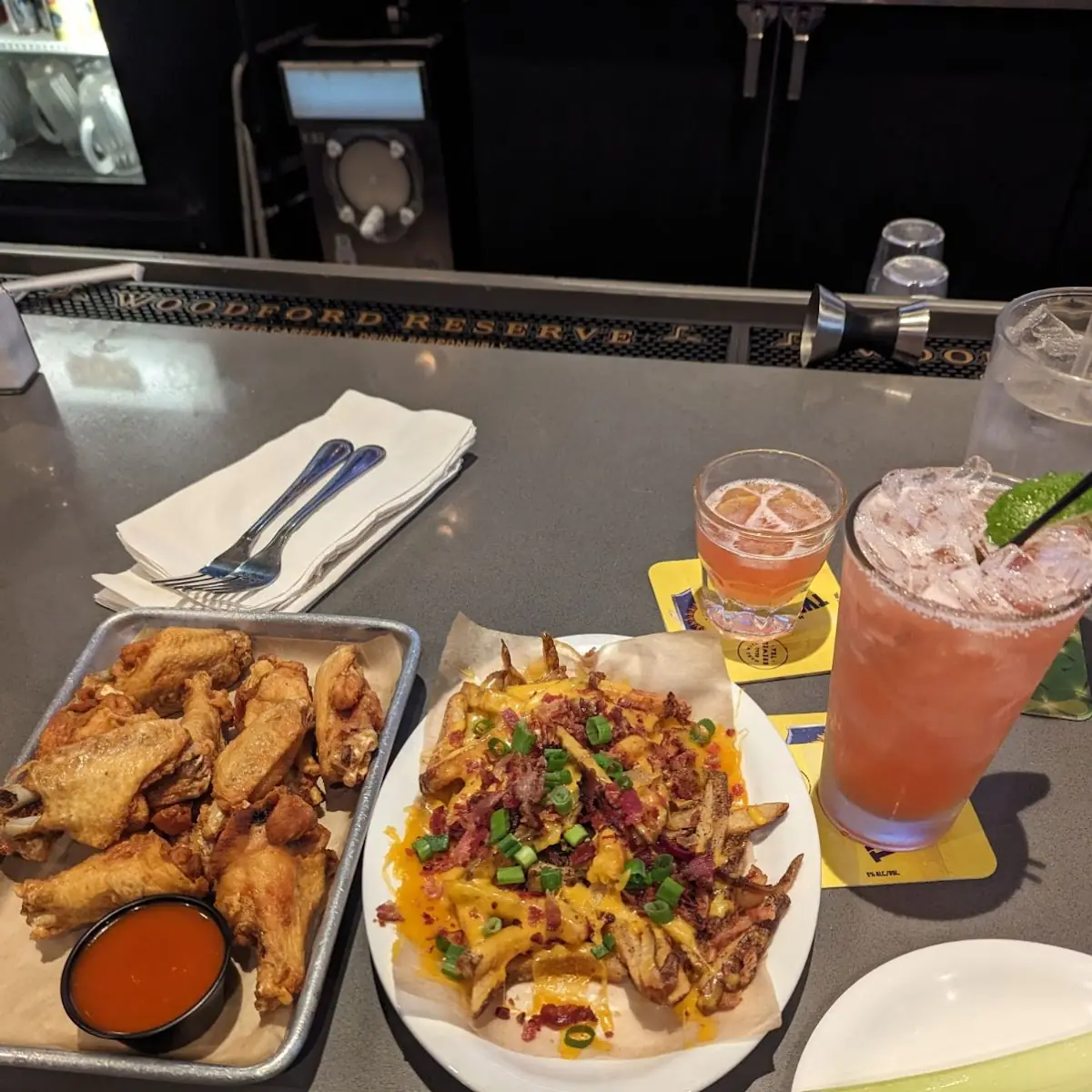 Plain Bone in Wings with Buffalo Sauce at the Side Loaded Fries and Spicy Watermelon Margarita