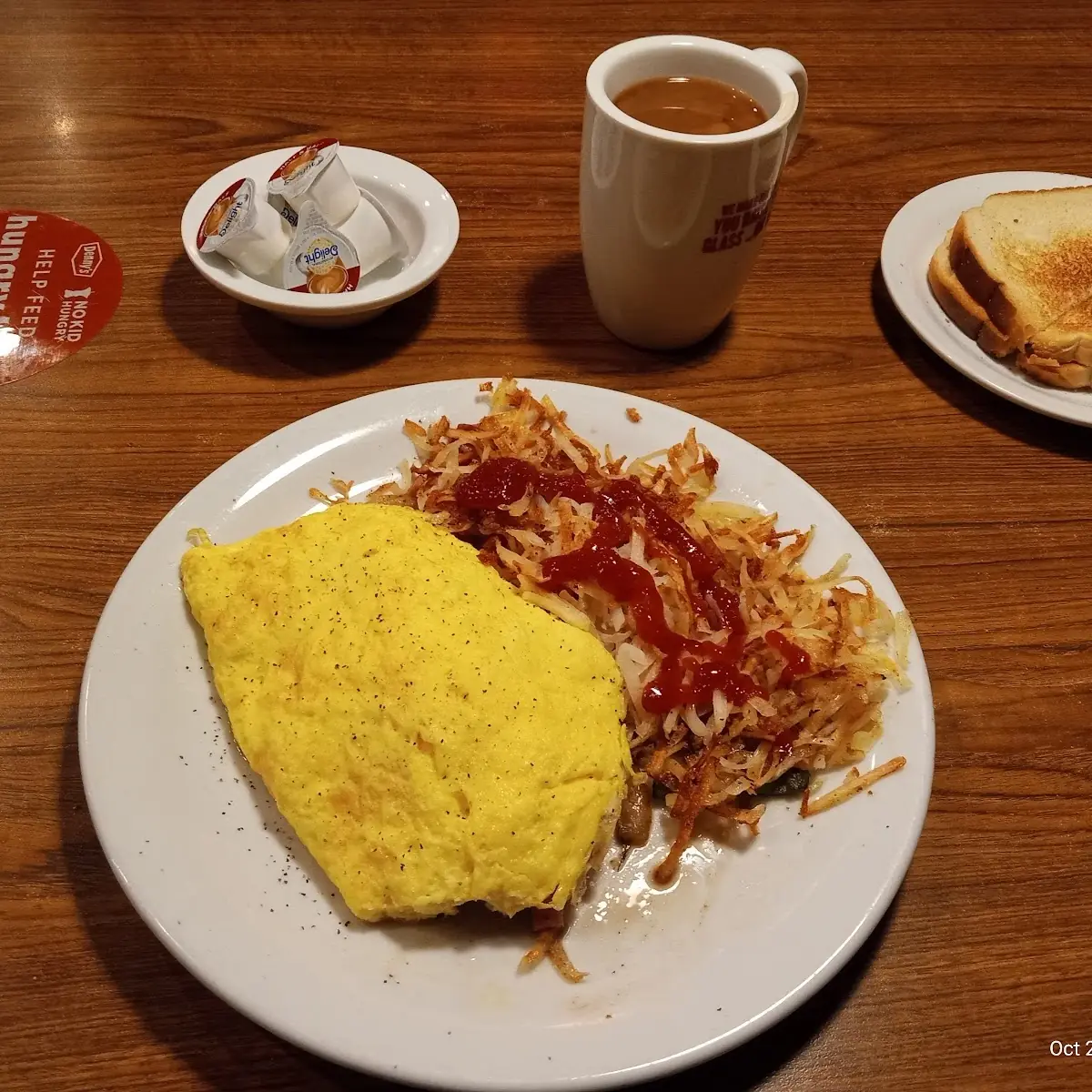 A Omelette with Has Browns with Ketchup on Them