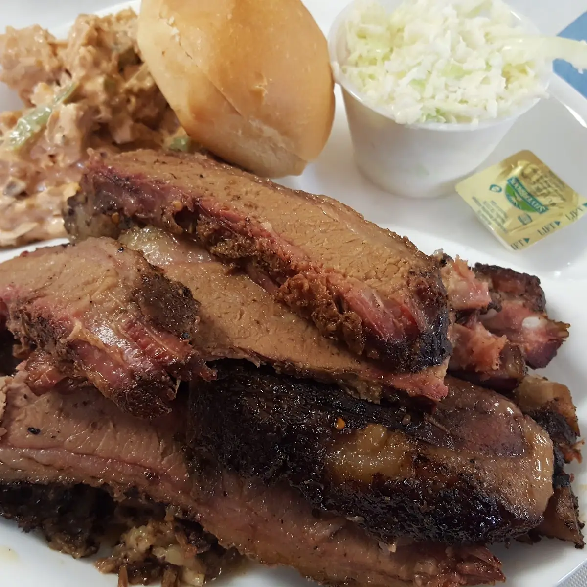 Brisket with Buffalo Wing Salad a Roll and Slaw