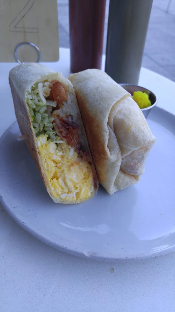 Breakfast Burrito with Scrambled Eco Bacon Cilantro Rice Cheddar Jack Grilled Onion
