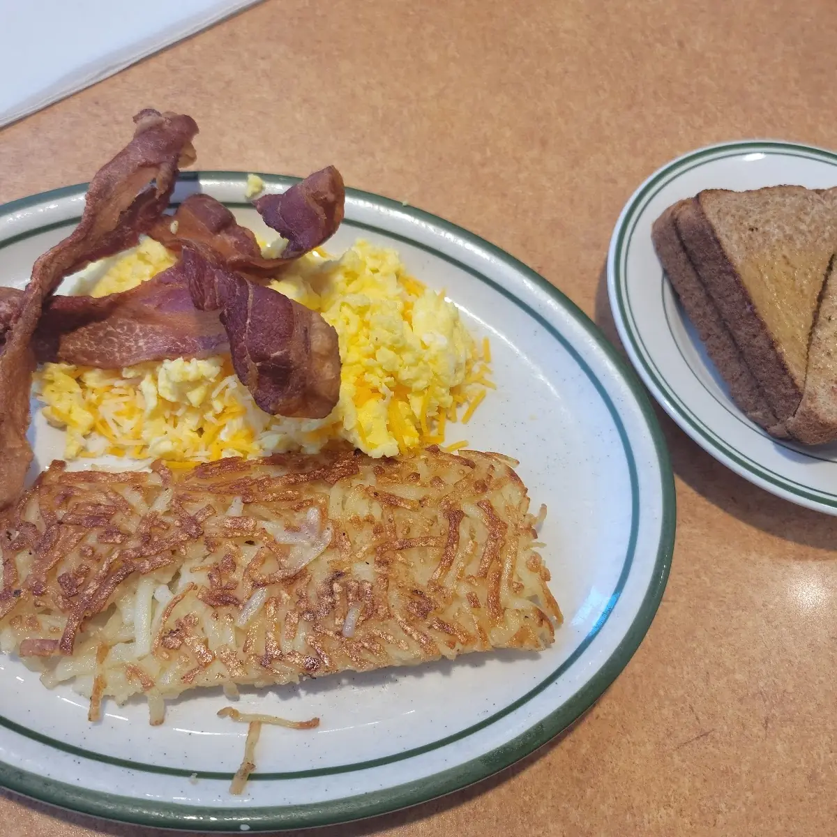 Scrambled Cheese Eggs Hash Browns Bacon and Grits