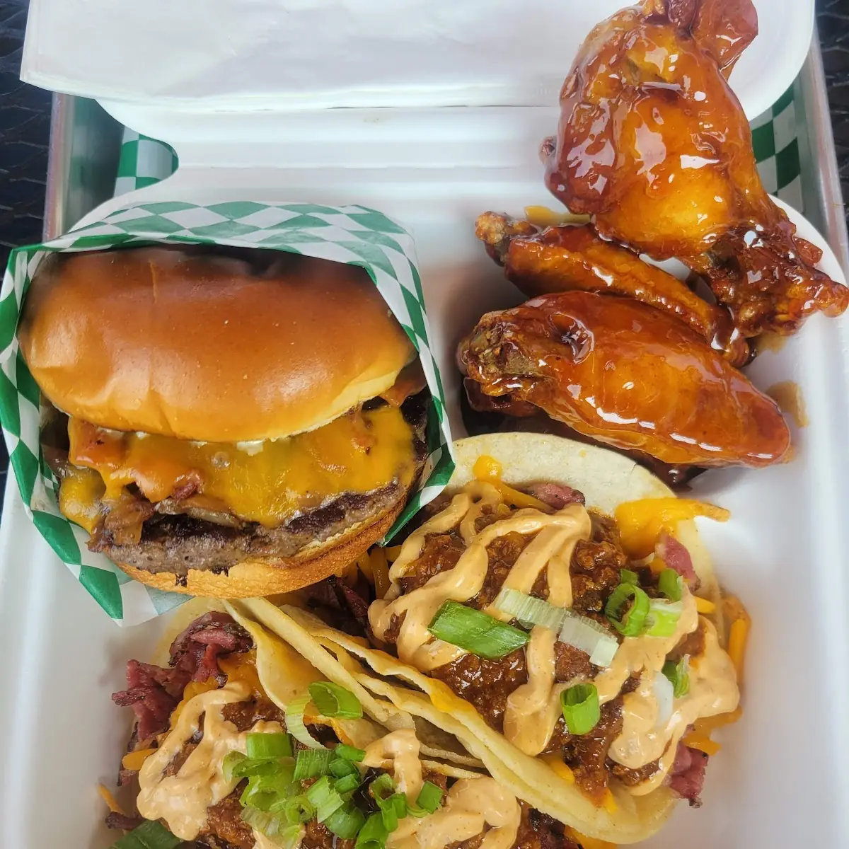 The Sample Box a Bacon Cheeseburger with Two Pastrami Chili Cheese Tacos and Wings