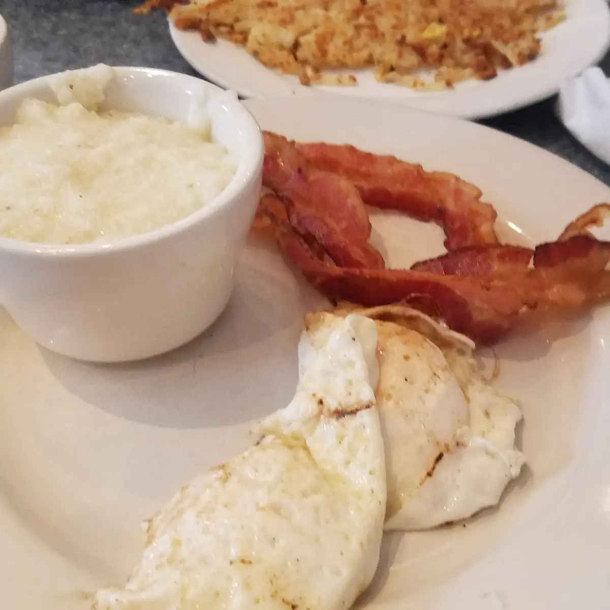 2 Eggs over Easy Bacon Grits Hash Brown’S and Toast