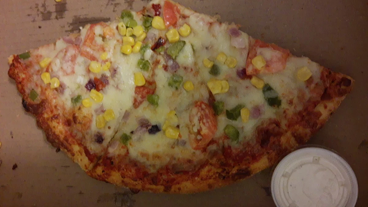 A Large Pizza with Sweet Corn Green Peppers Red Onion Roma Tomato