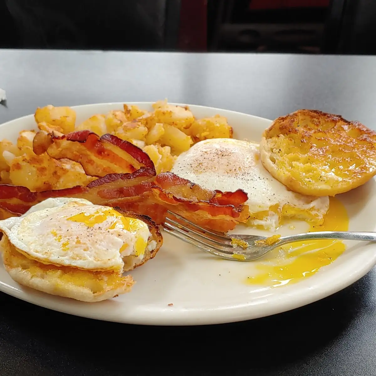 Two Eggs over Easy Bacon Crisp Home Fries Well-Done and an English Muffin