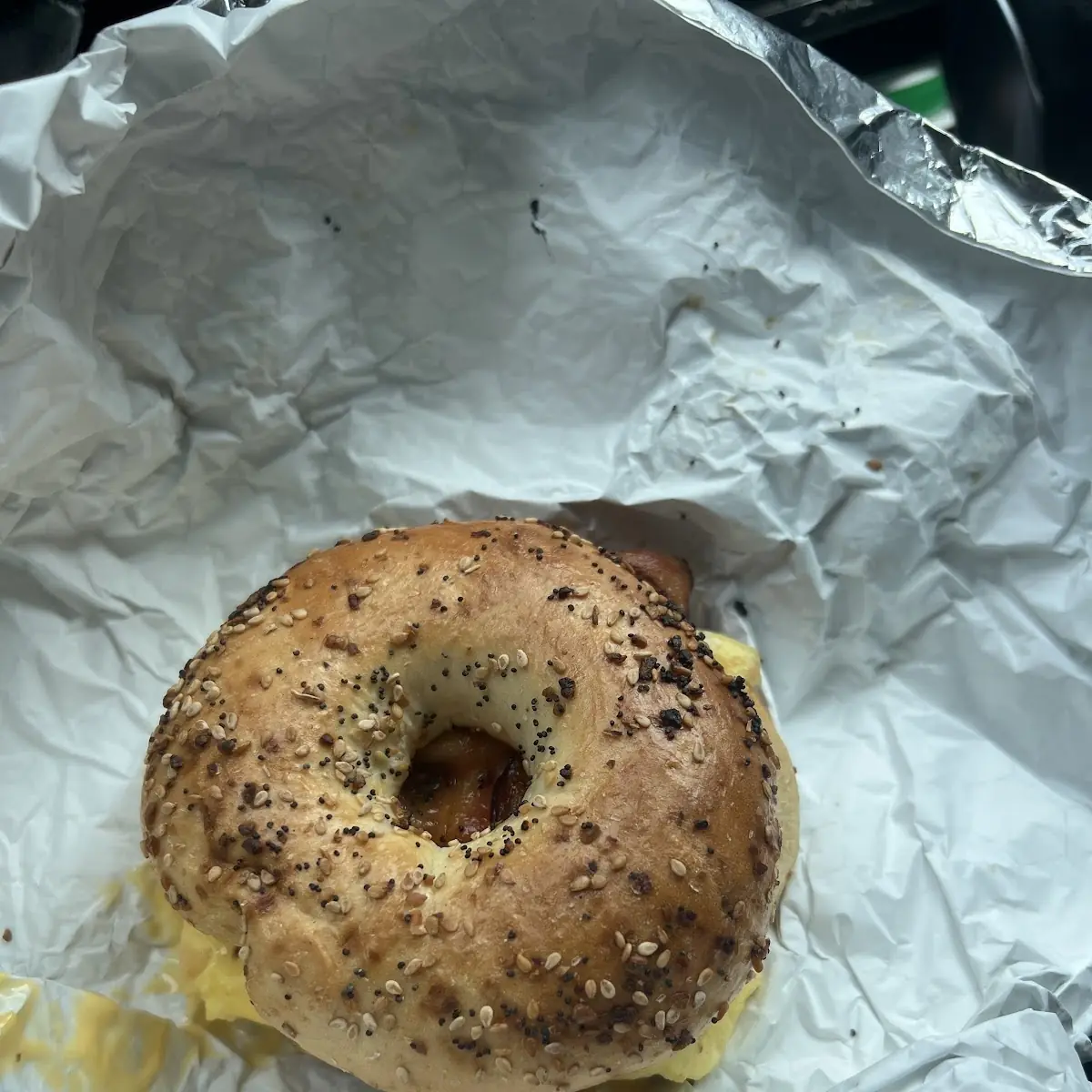 Two Scrambled Eggs with Cheese and Bacon on a Sesame Bagel