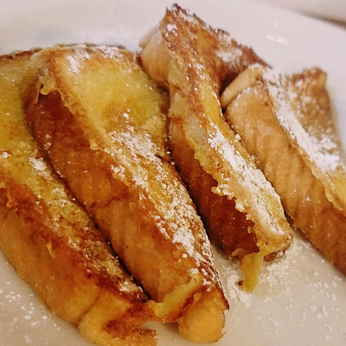 French Toast Combo with Four Triangles Two Eggs and Choice of Bacon or Sausage