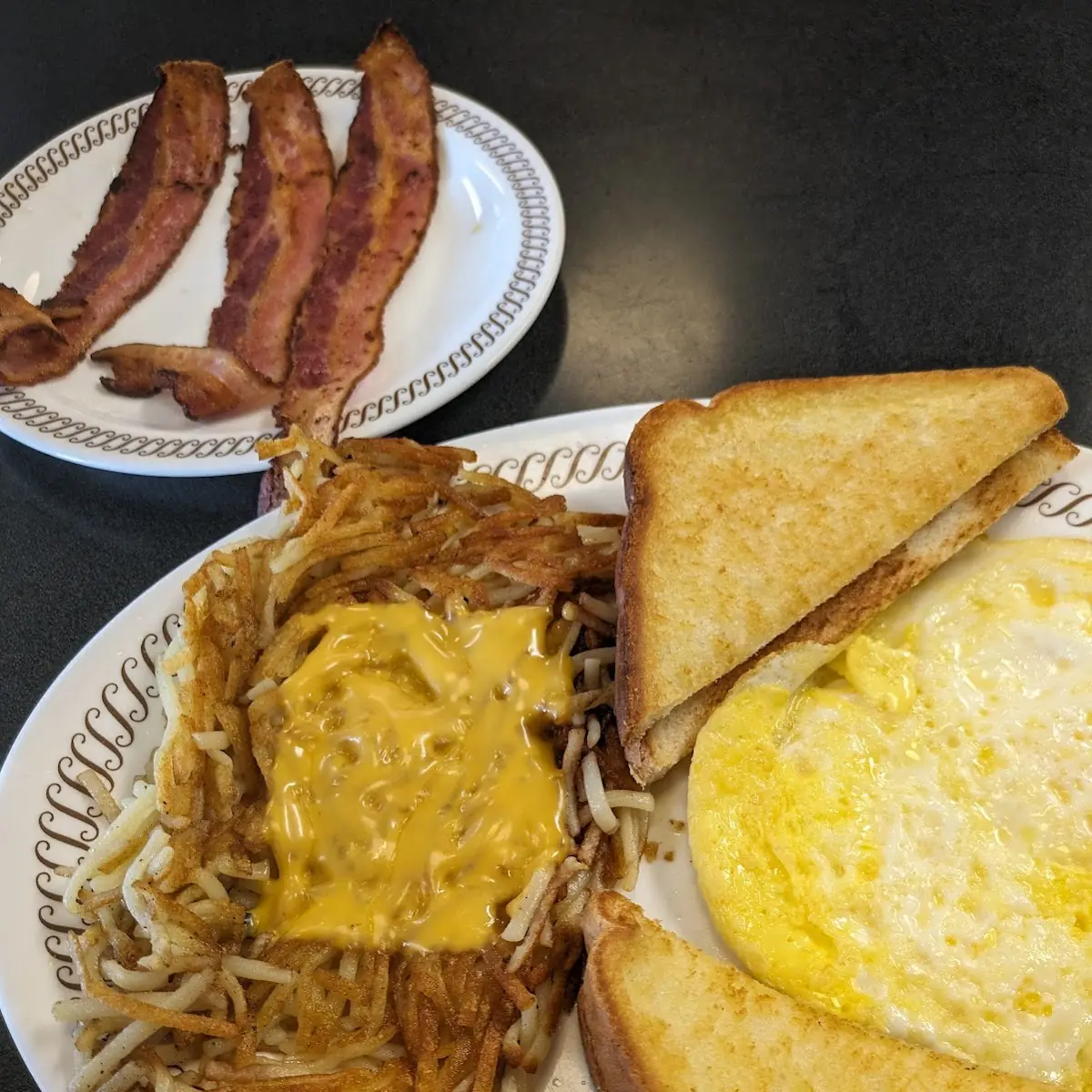 Hashbrowns Covered Scattered Toast on Grill Fried Eggs and Bacon