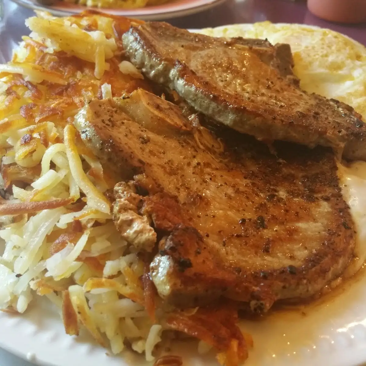 Pork Chops Served with 2 Eggs Hash Brown Savory Sausage Gravy and Toast