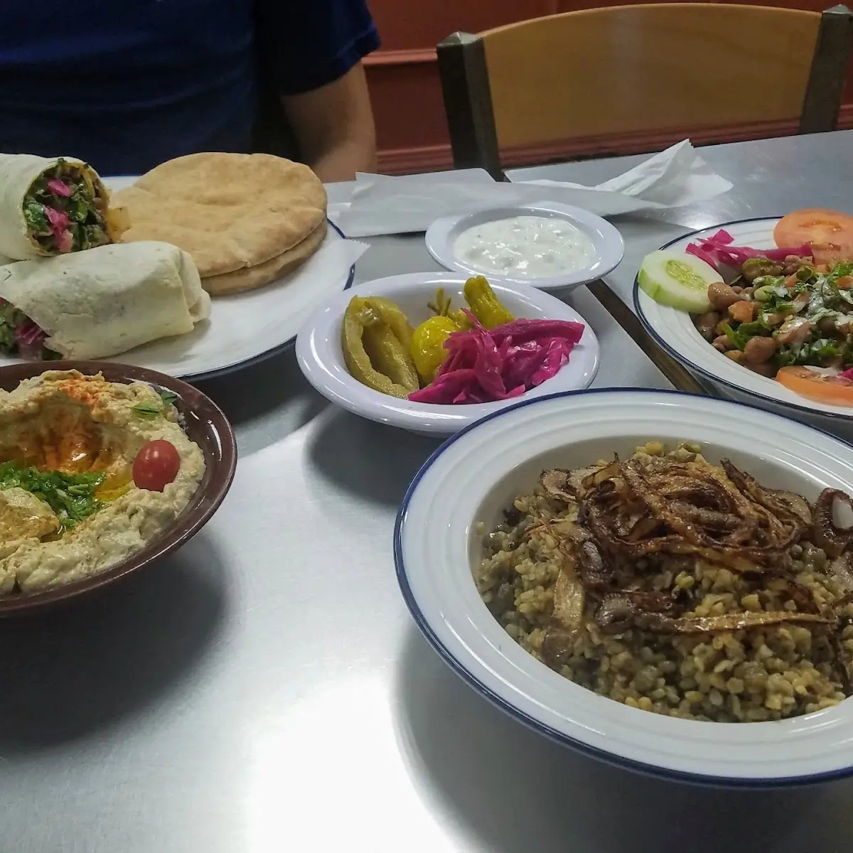 Clockwise from Top Left Lamb Shawarma Wrap Ful Medames Mujadara and Baba Ganouj