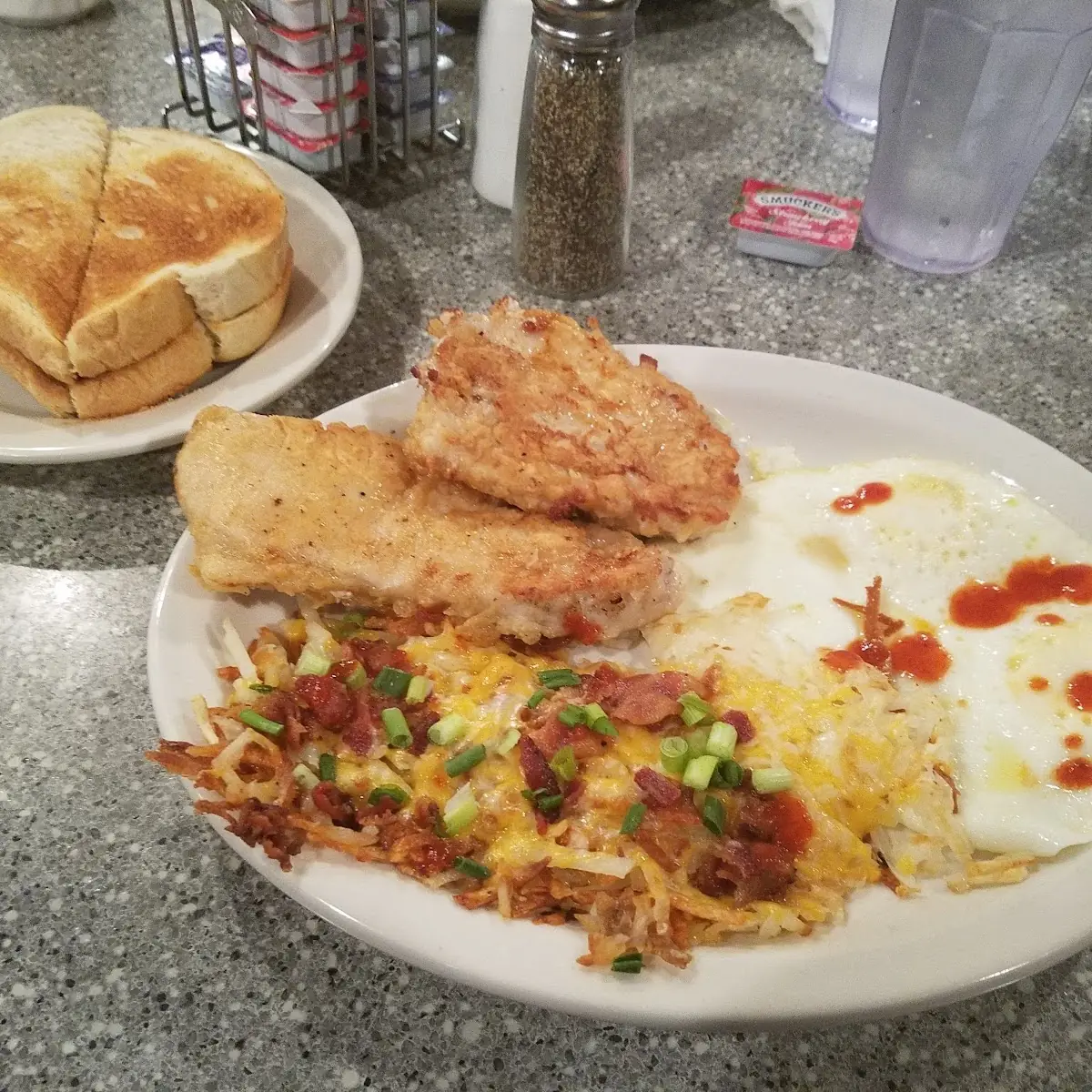 Pork Chops 2 Eggs over Medium Loaded Hash Browns and Sourdough Toast