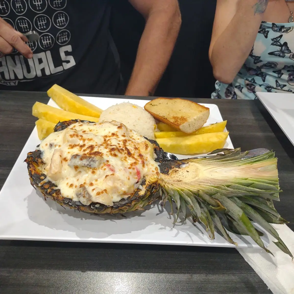 Piña Azteca Fresh Pineapple Stuffed with Shrimp Crab Meat and Steak Topped with Melted Cheese