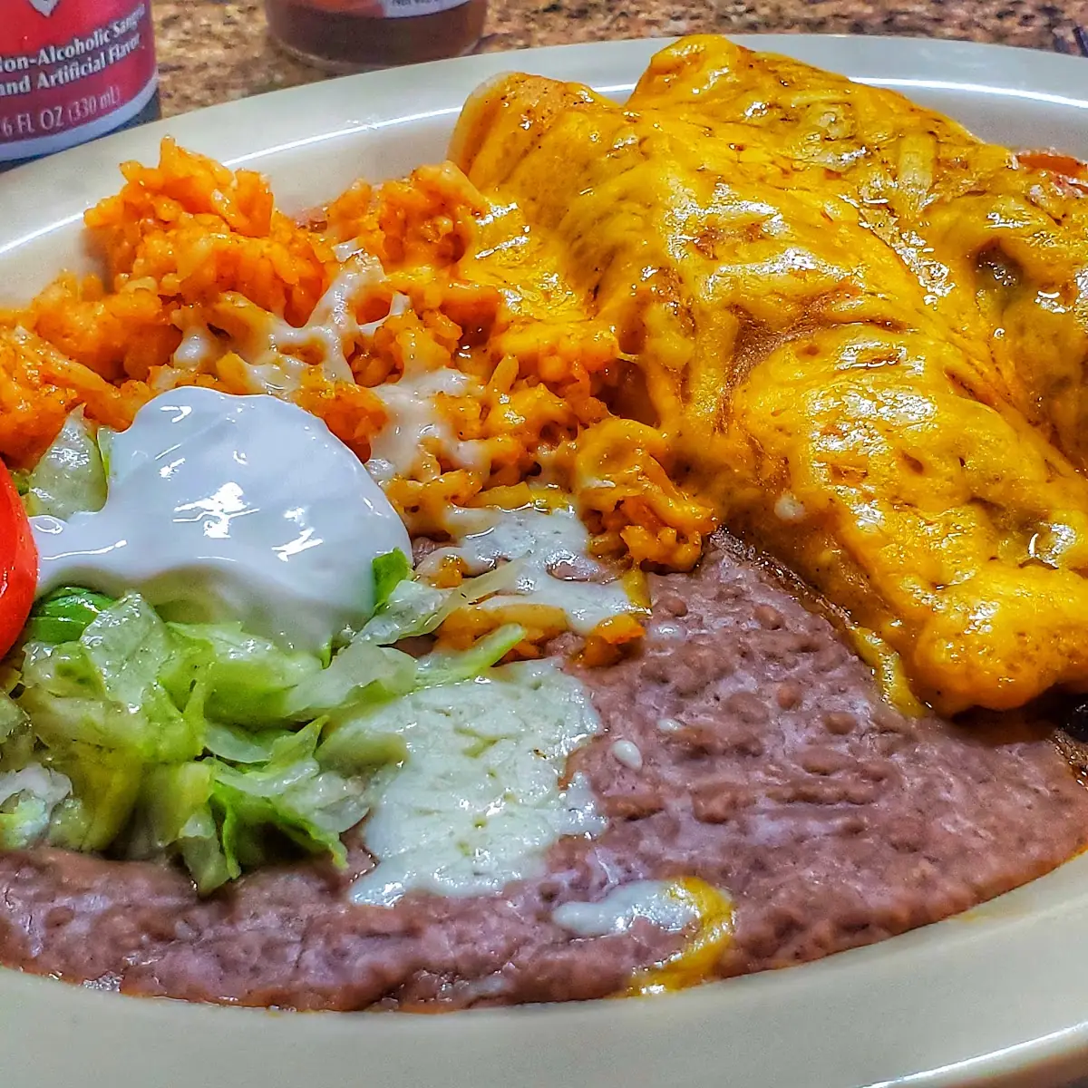 2 Enchiladas Refried Beans & Rice