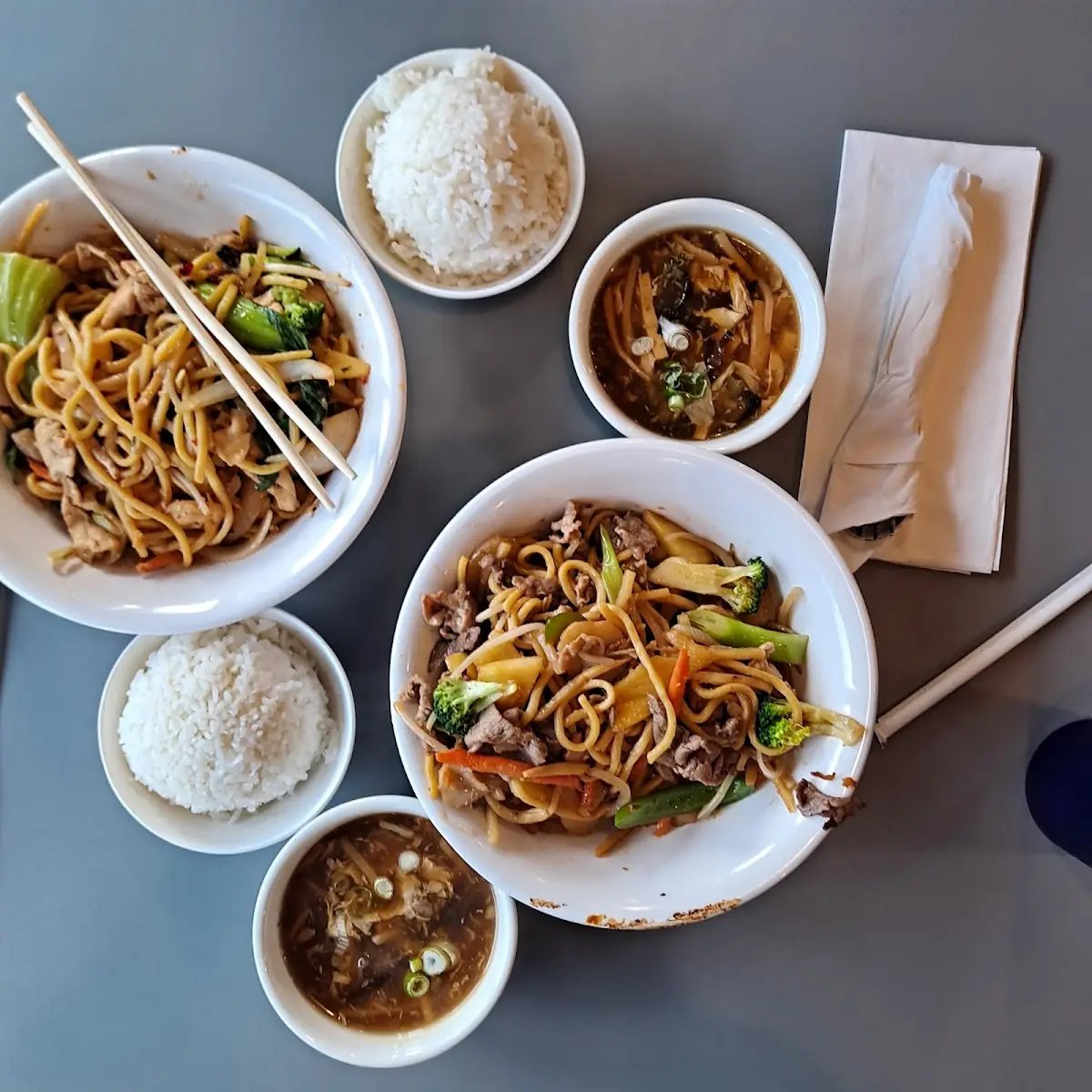 Two Bowls Two Egg Rolls Fried and Steamed Rice and a Bowl of Egg Drop Soup