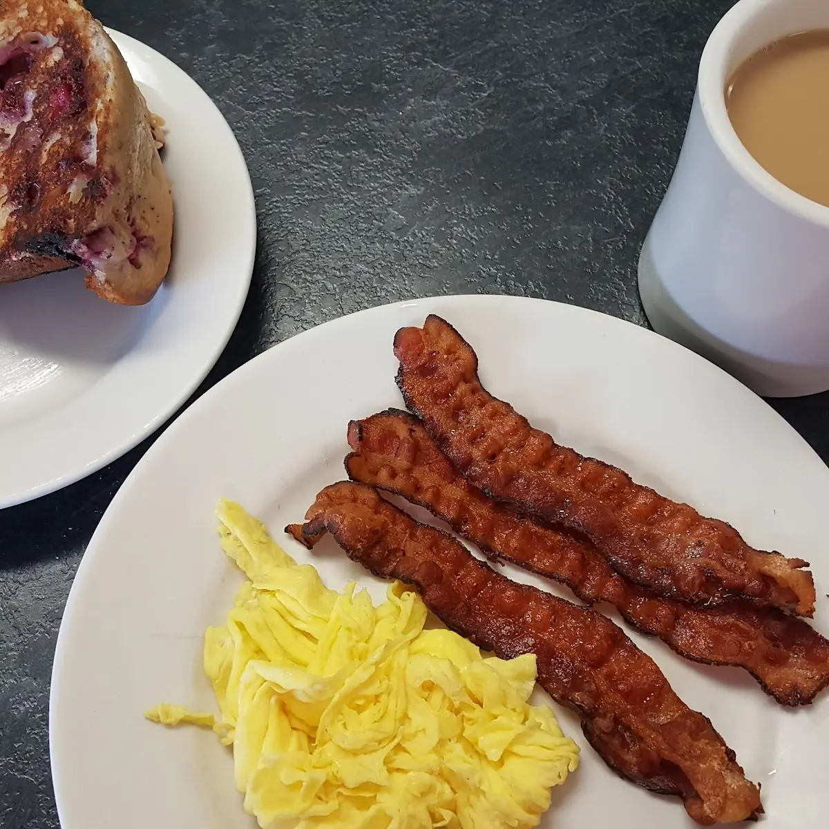 Scrambled Eggs Grilled Raspberry Muffin and Crispy Bacon and a Coffee