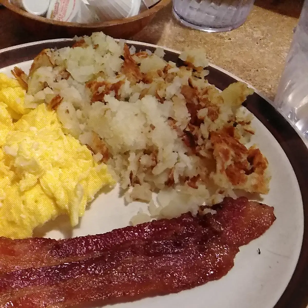 1 scrambled egg and bacon over a bagel with cream cheese
