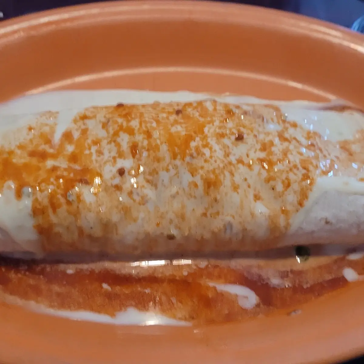 #18 Steak and Chicken Burrito Topped with Melted Cheese and Sour Cream, Served with Rice, Lettuce, Pico De Gallo and Guacamole