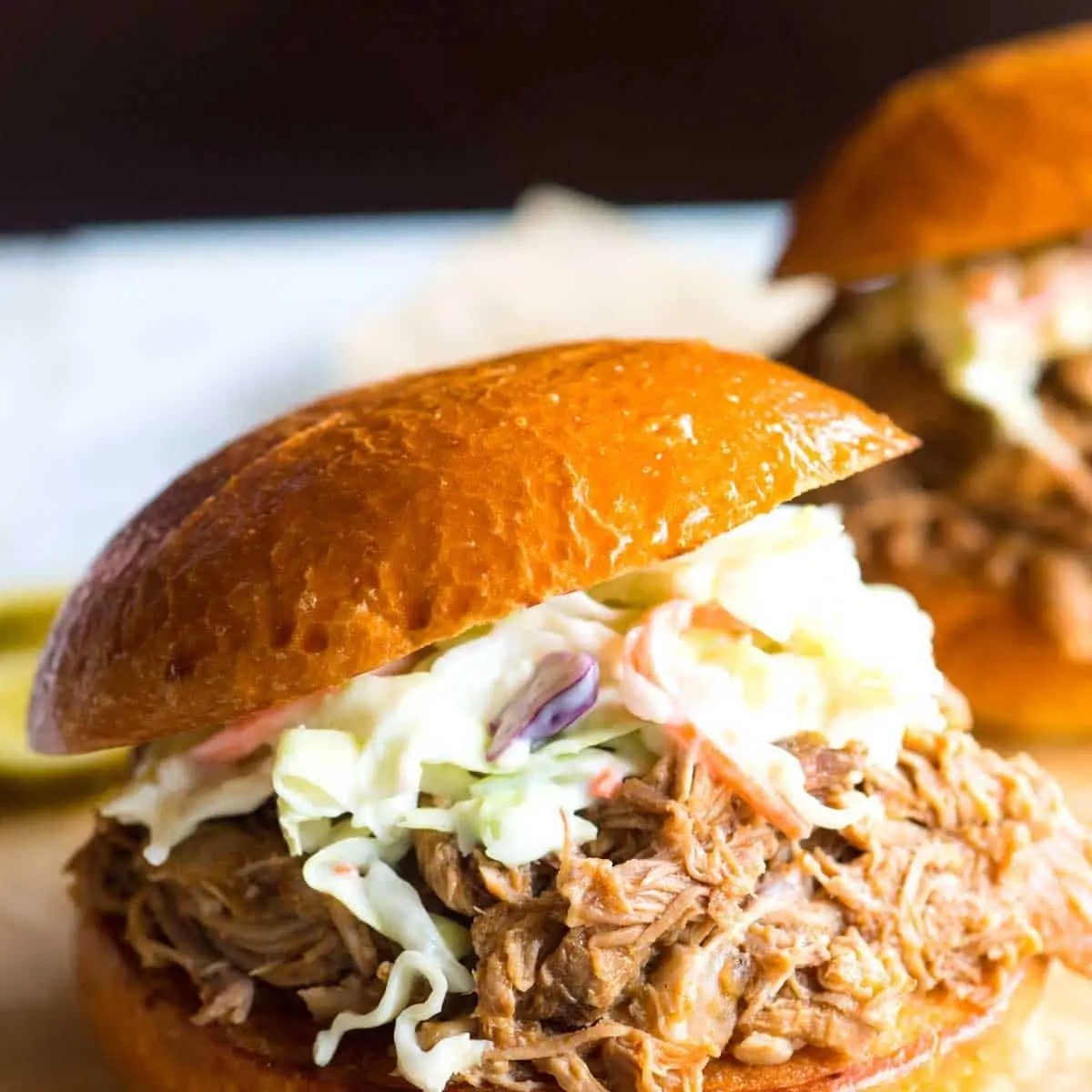 Pulled Pork Sandwich with Pickles and BBQ Sauce Carolina-Style Coleslaw on Top 1
