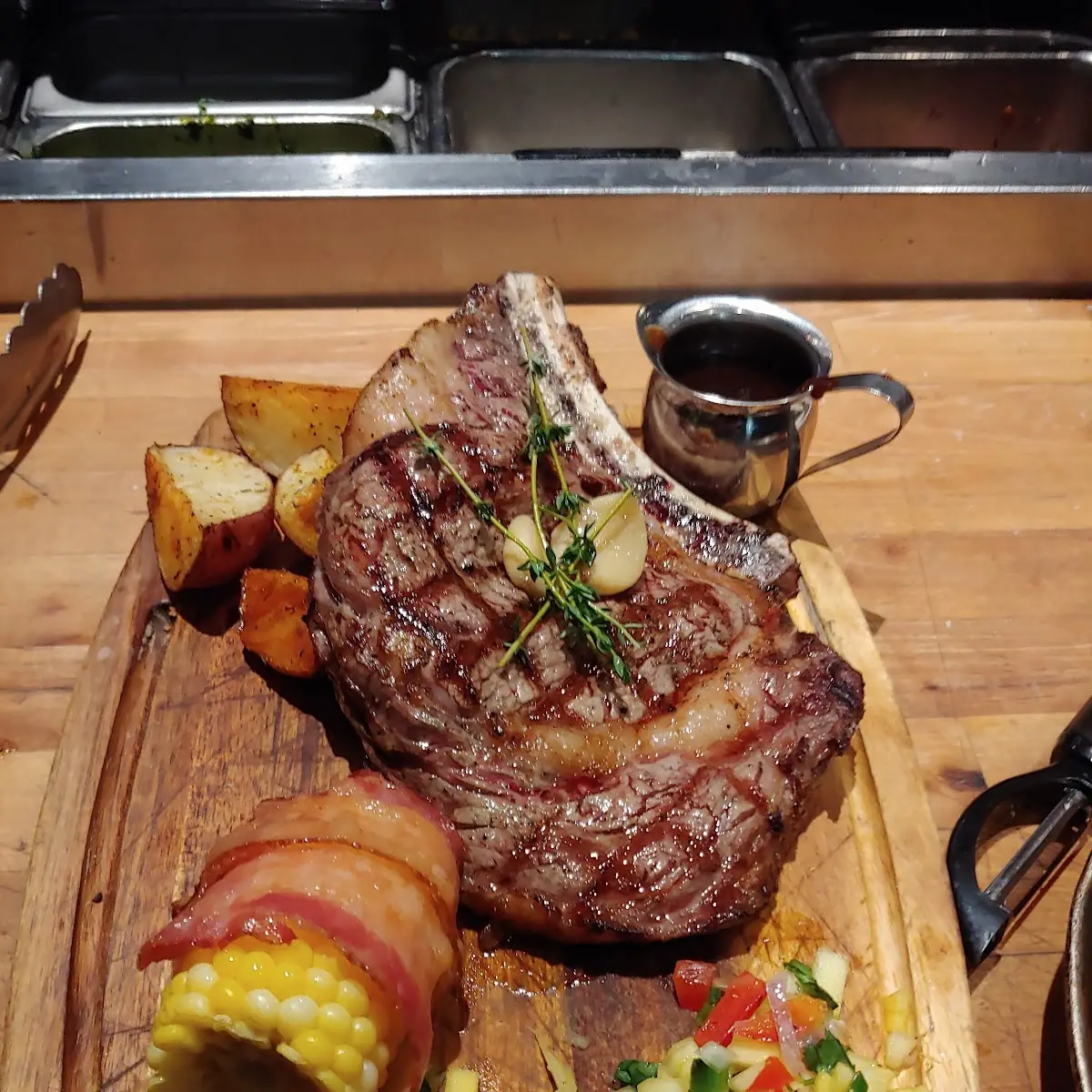 Bone in Ribeye Bacon Wrapped Corn Cob Roasted Potatoes Mango Salsa