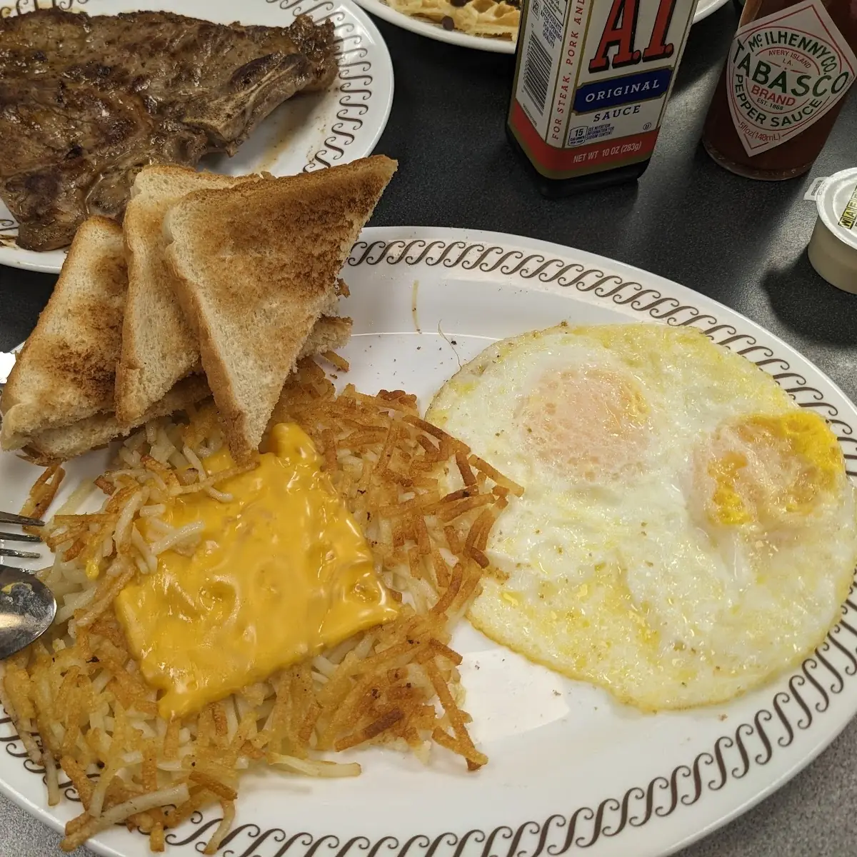 T-Bone Steak and Eggs with Cheese on Hashbrowns