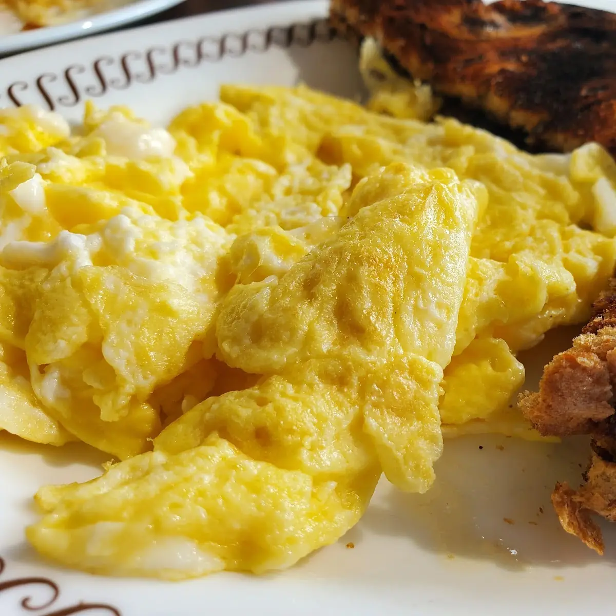 Scrambled Eggs Grits and Well Done Raisin Toast