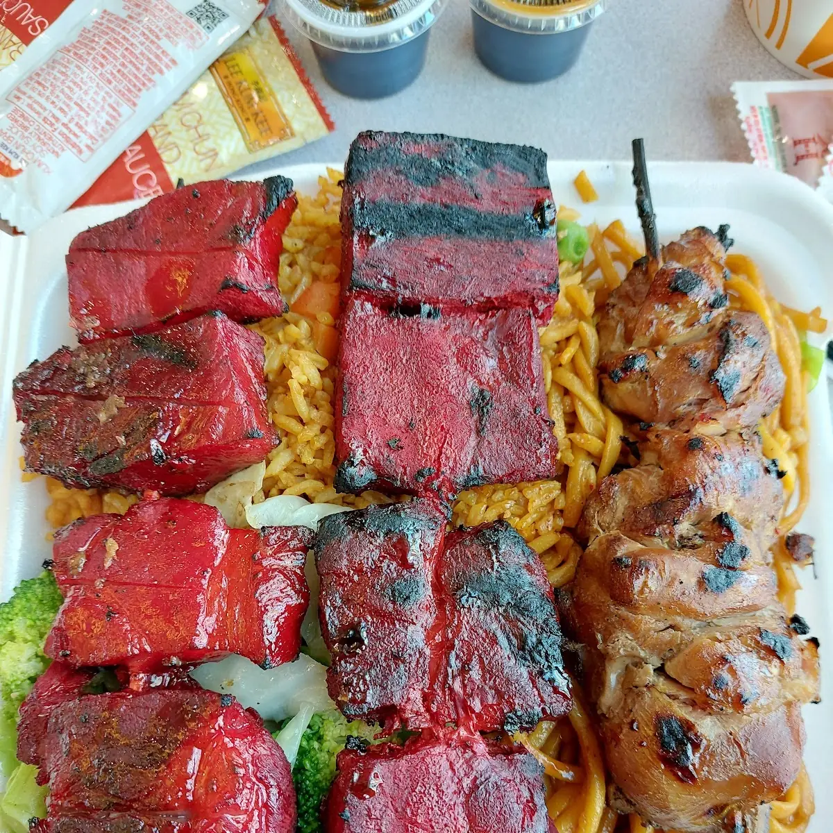 Beef Pork and Chicken BBQ Kabobs on Steamed Vegetables Fried Rice and Noodles