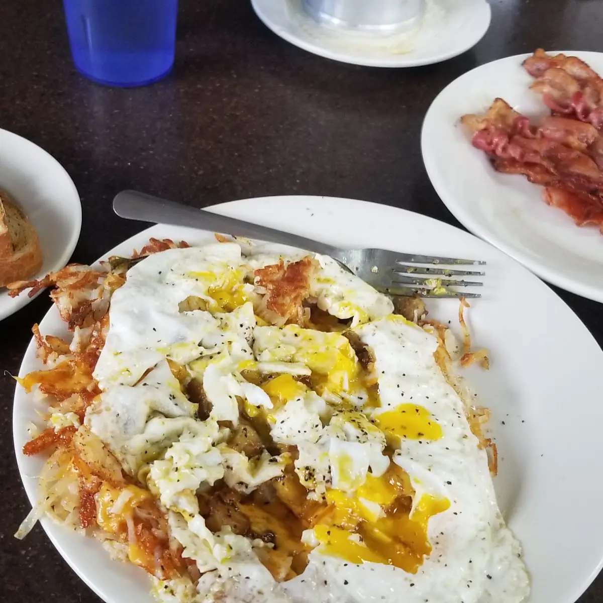 Overeasy Eggs Atop Hashbrowns w Bacon Ant Rye Toast