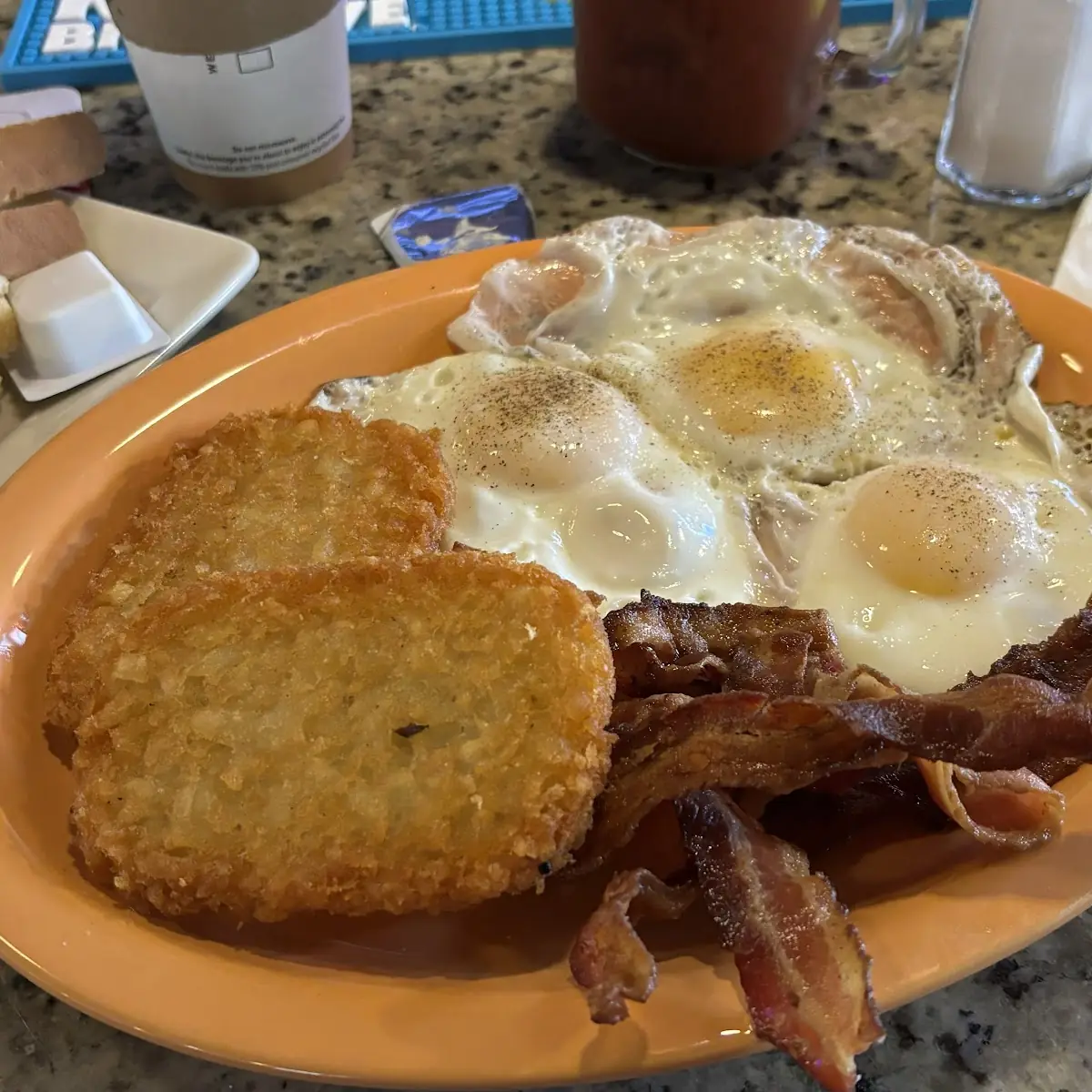 Three Eggs over Easy Bacon Hash Brown with Sour Dough Toast and Butter
