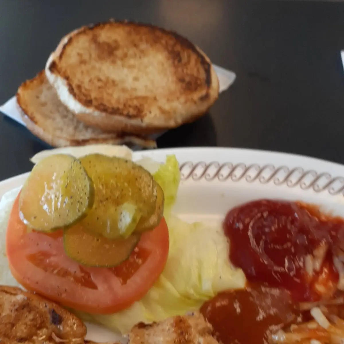 Grilled Chicken Breast Sandwich with Lettuce Tomatoes and Pickles on the Side Hasbrowns