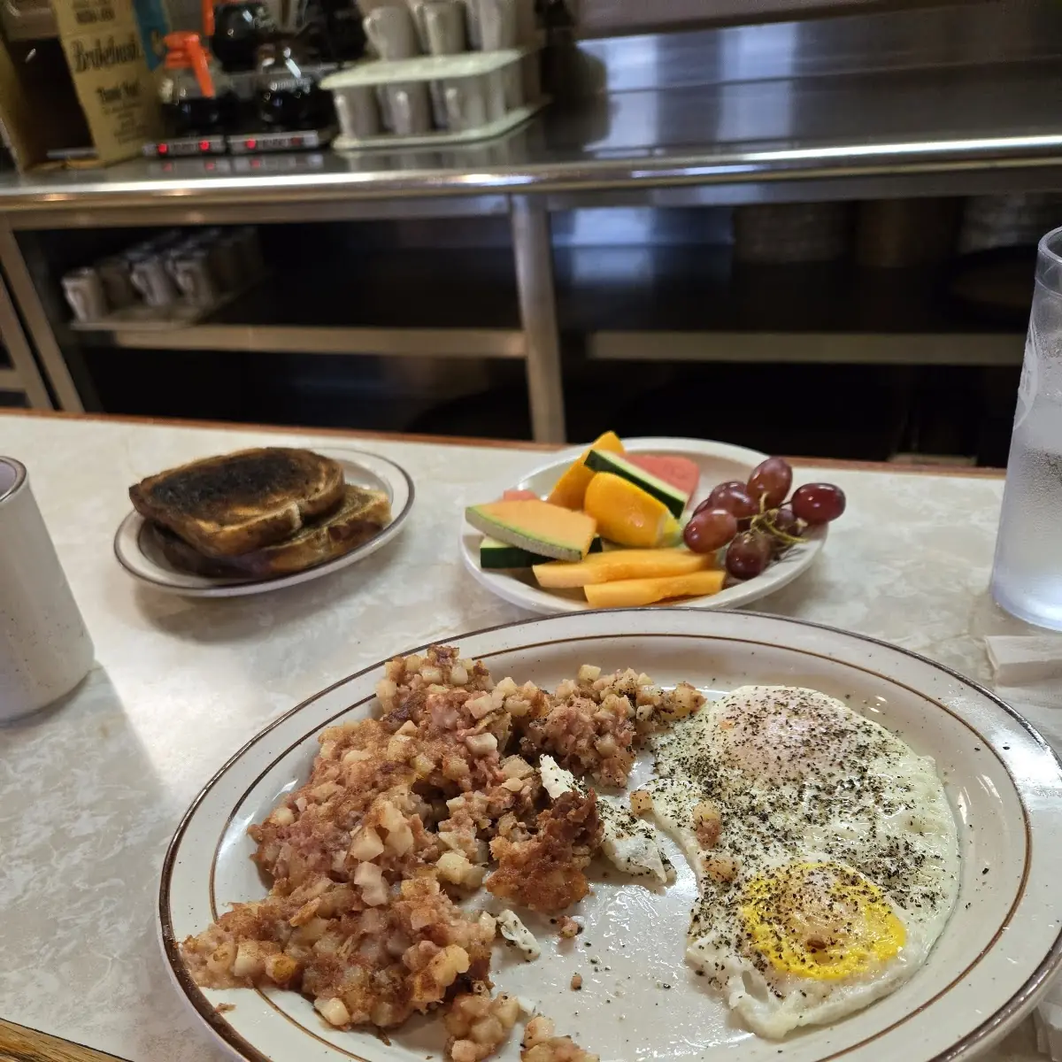 Over Easy Eggs and Corned Beef Hash with Fruit