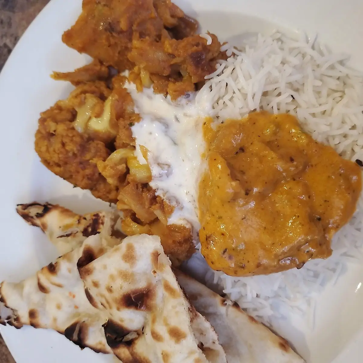 Clockwise from Bottom Nann Aloo Gobi Jasmine Rice and Butter Chicken