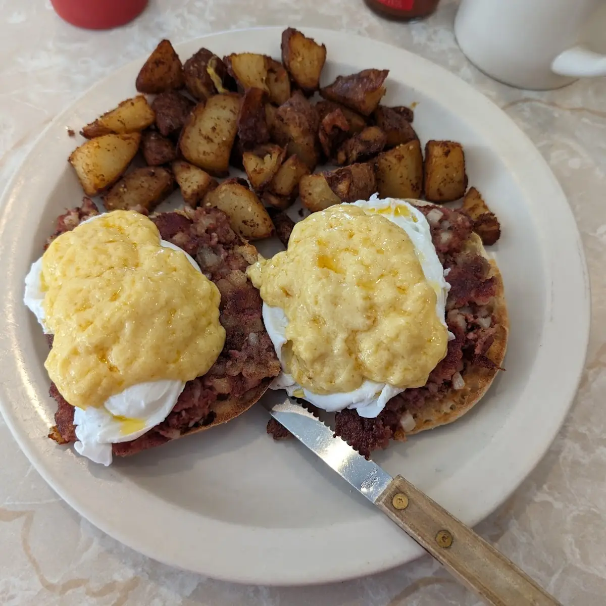 Sam's Benedict Poached Eggs Hollandaise Sauce and Corned Beef Hash on English Muffin with Home Fries