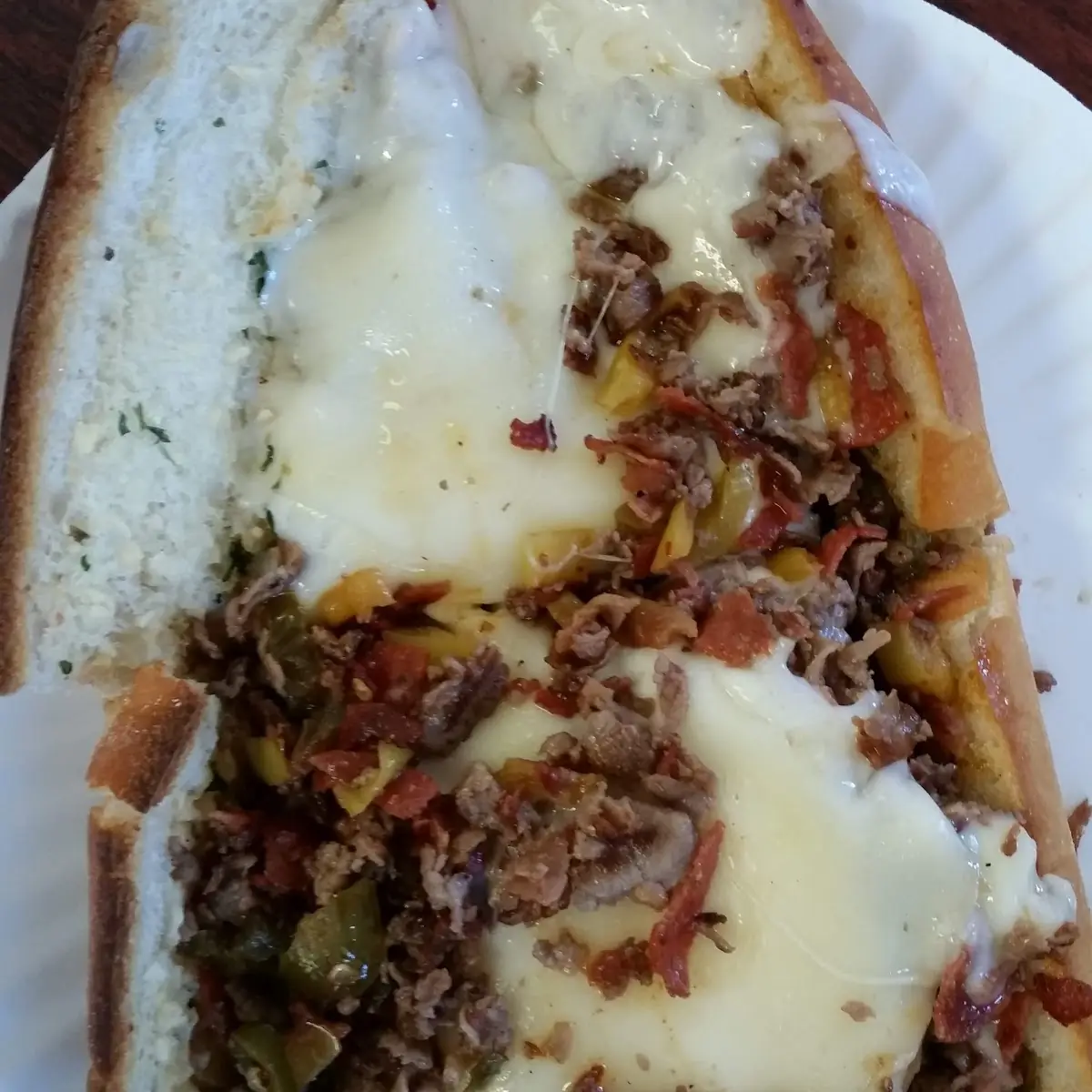 Bacon Pepperoni Three Cheese Cheese Steak on Toasted Garlic Bread with Jalapenos and Banana Peppers