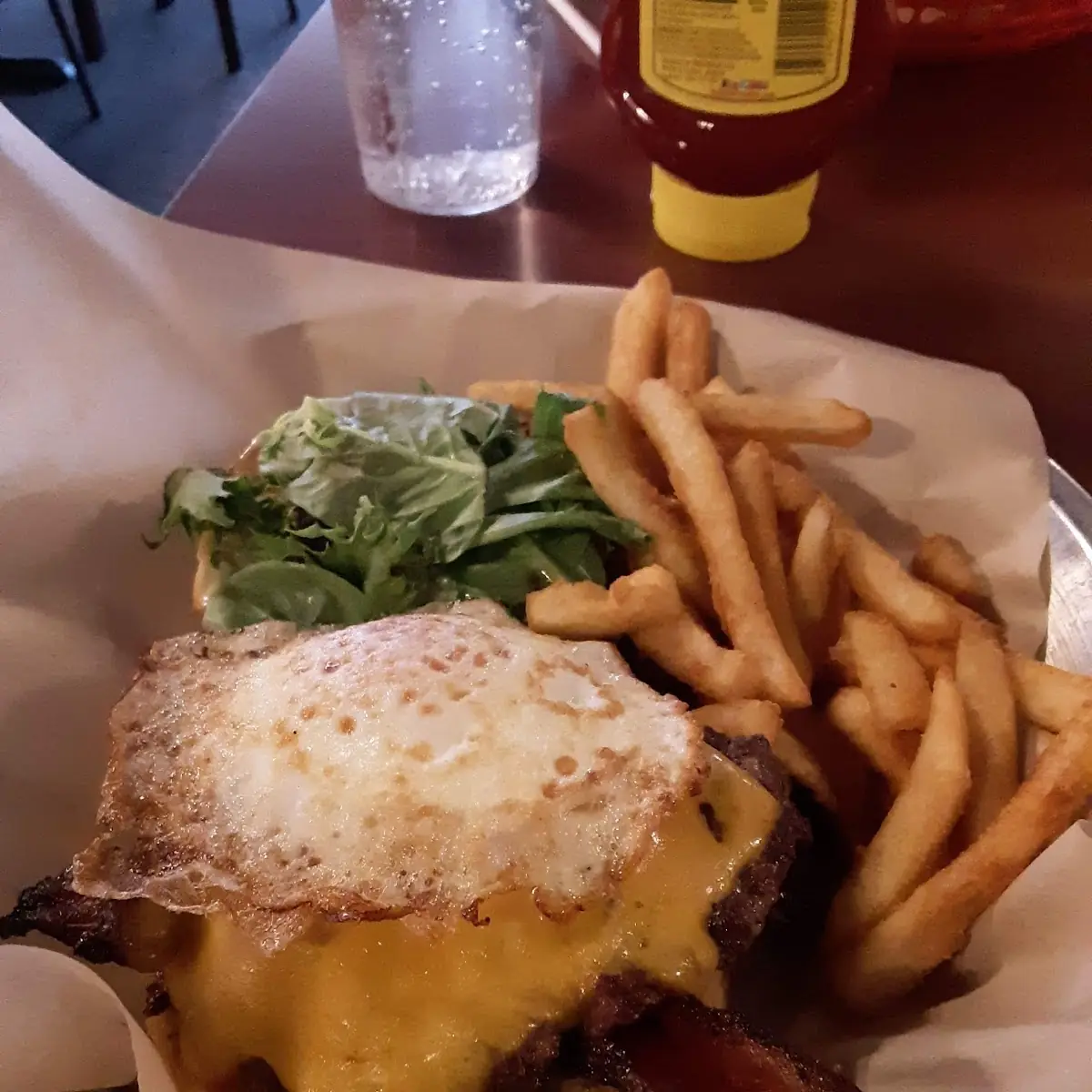 Cheddar Bacon Cheeseburger Topped with Fried Egg and Fries