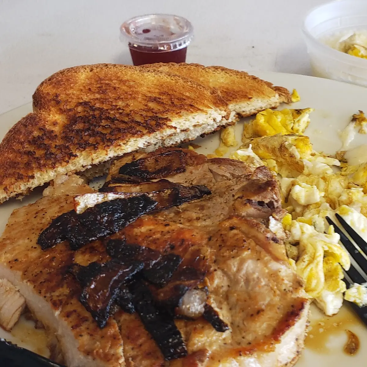 Grilled Pork Chop with Grits Scrambled Eggs and Toast