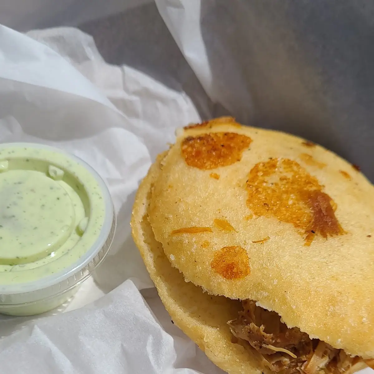 A Pulled Pork and Cheese Arepa w Mom's Sauce