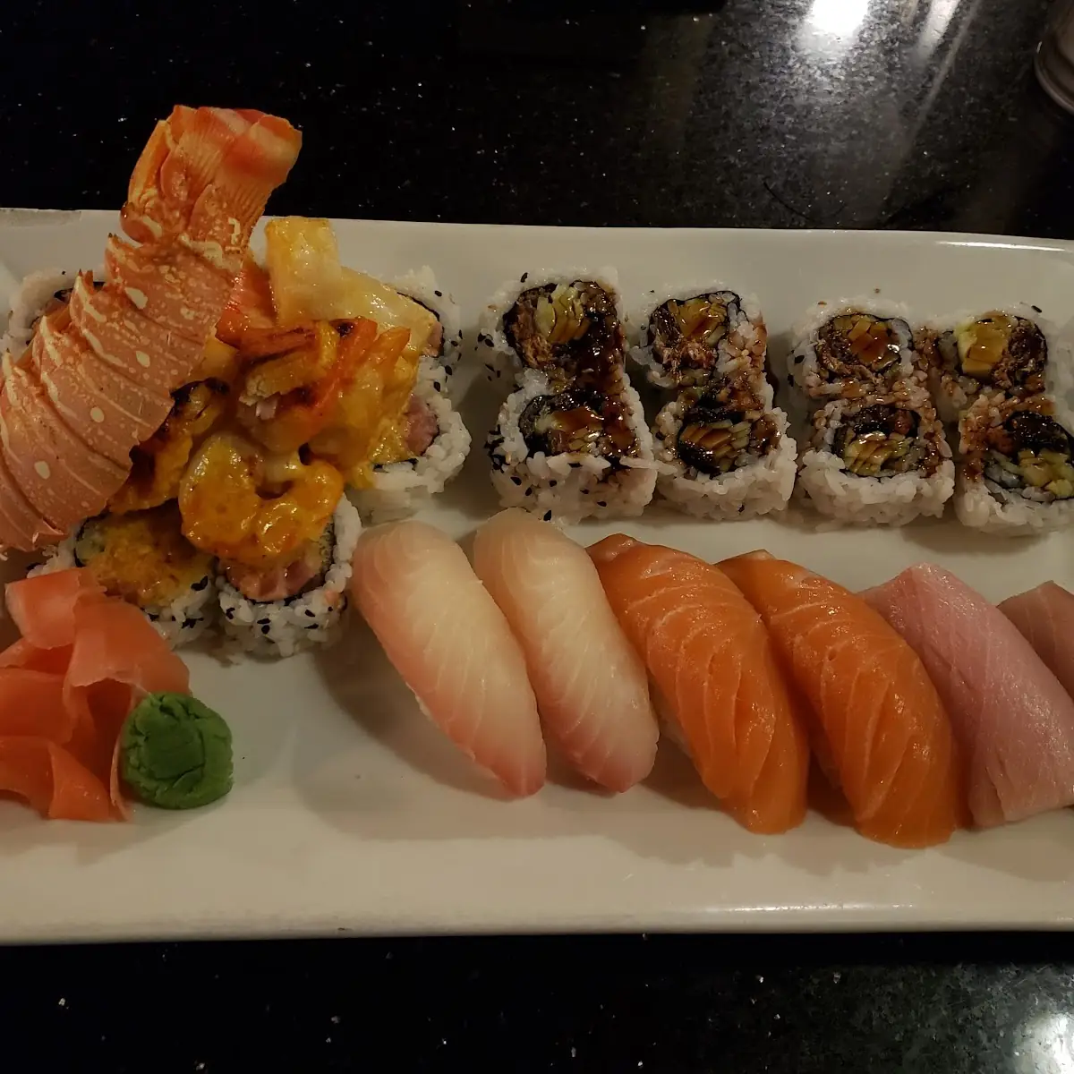 Lobster Roll Left Salmon Skin Roll Right Hamachi Nigiri Salmon Nigiri and White Fish Nigiri