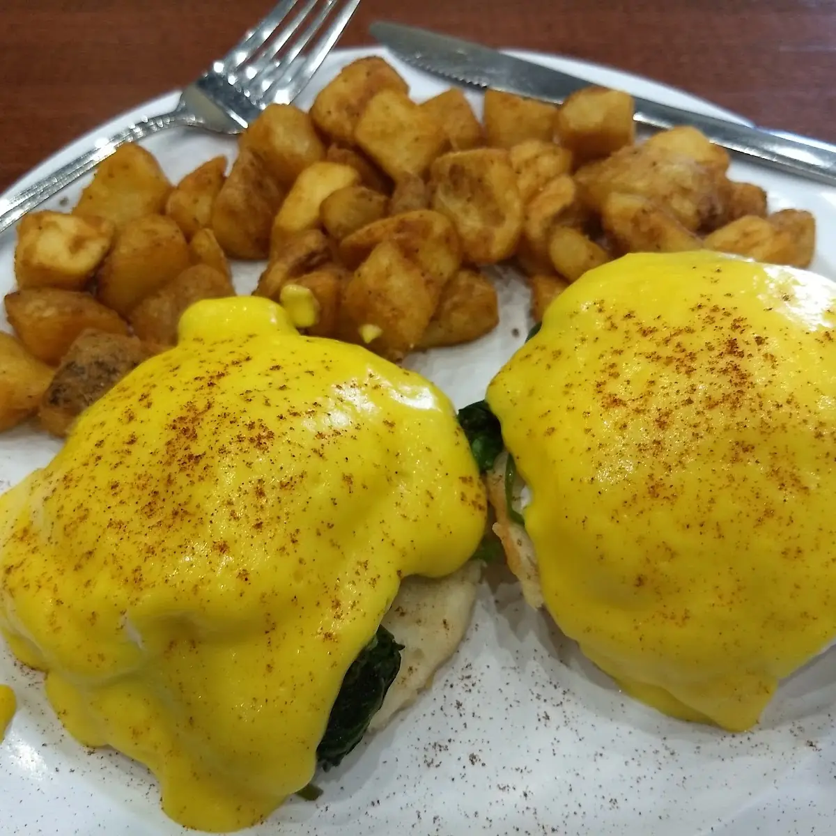 Eggs Benedict with Spinach Served on a Biscuits & Gravy Fries