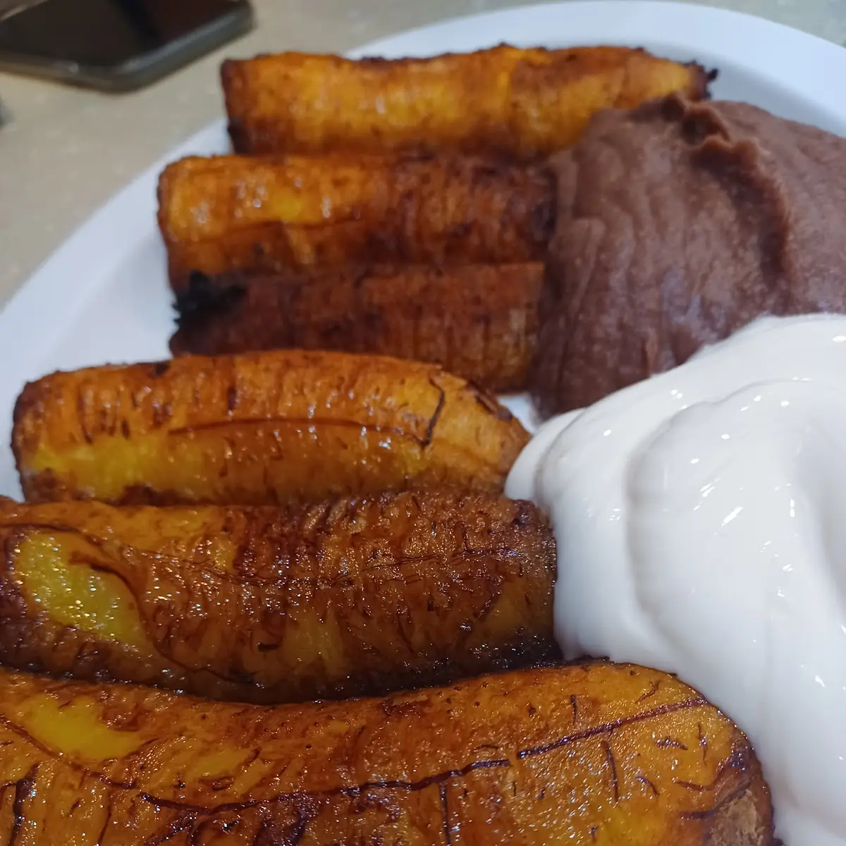 Fried Plantains with Refried Black Beans and Cream