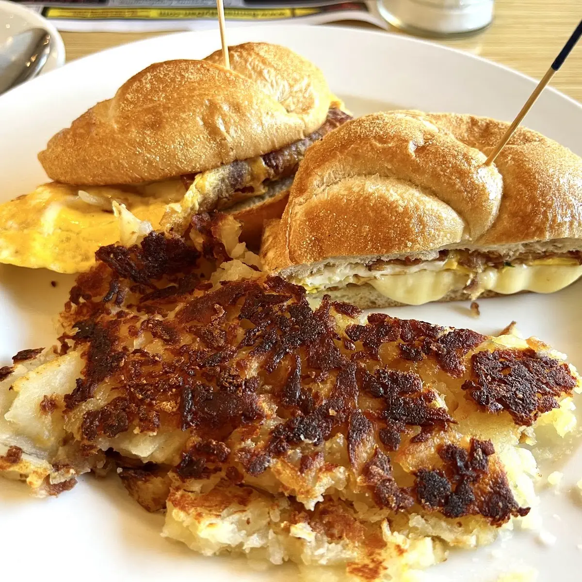 Scrambled Eggs with Bacon on a Kaiser Roll and Hash Browns