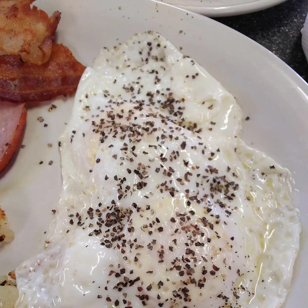 Over Easy Eggs Sprinkled with Black Pepper