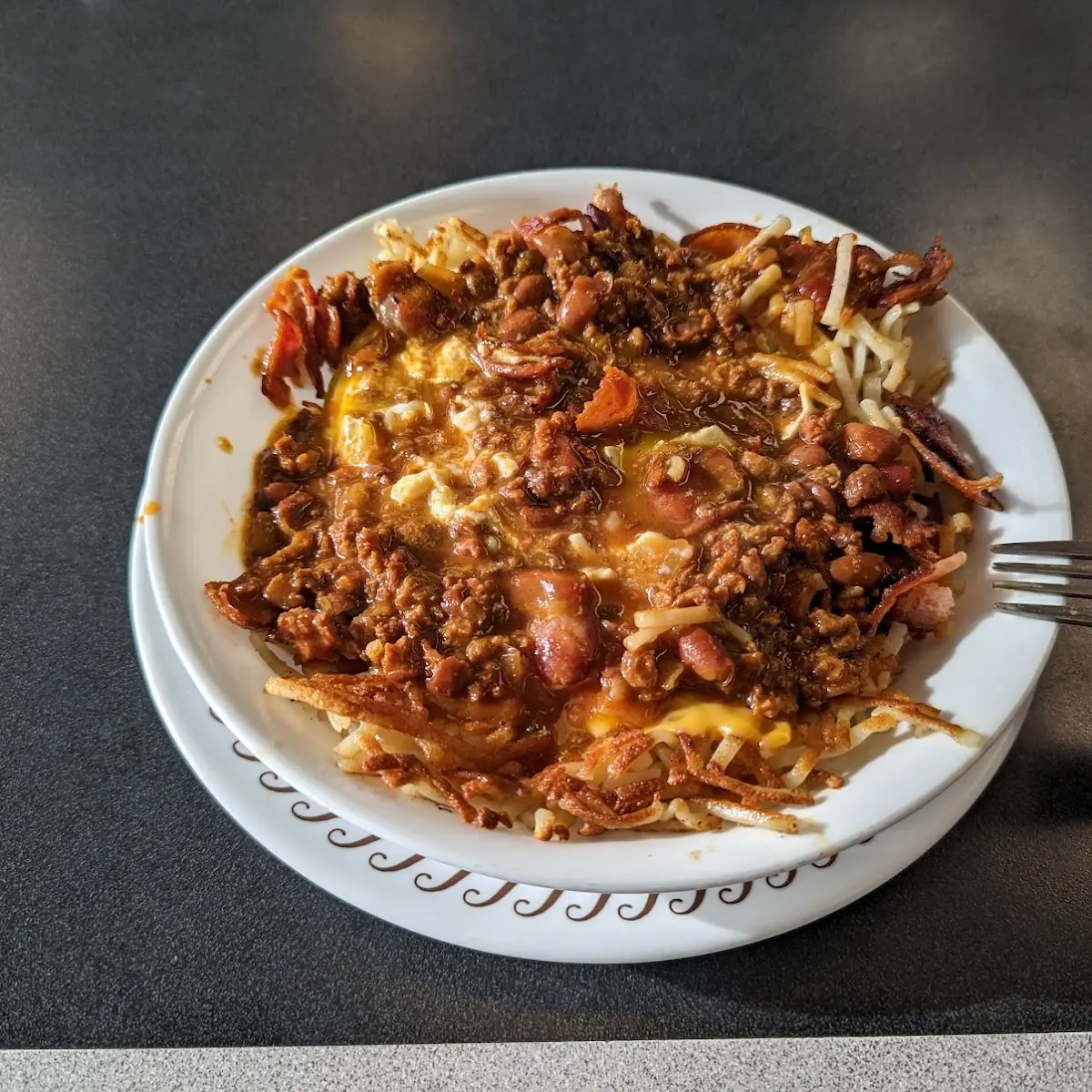 Bacon Hash Brown Bowl with 3 Eggs over Easy and Chilli on Top