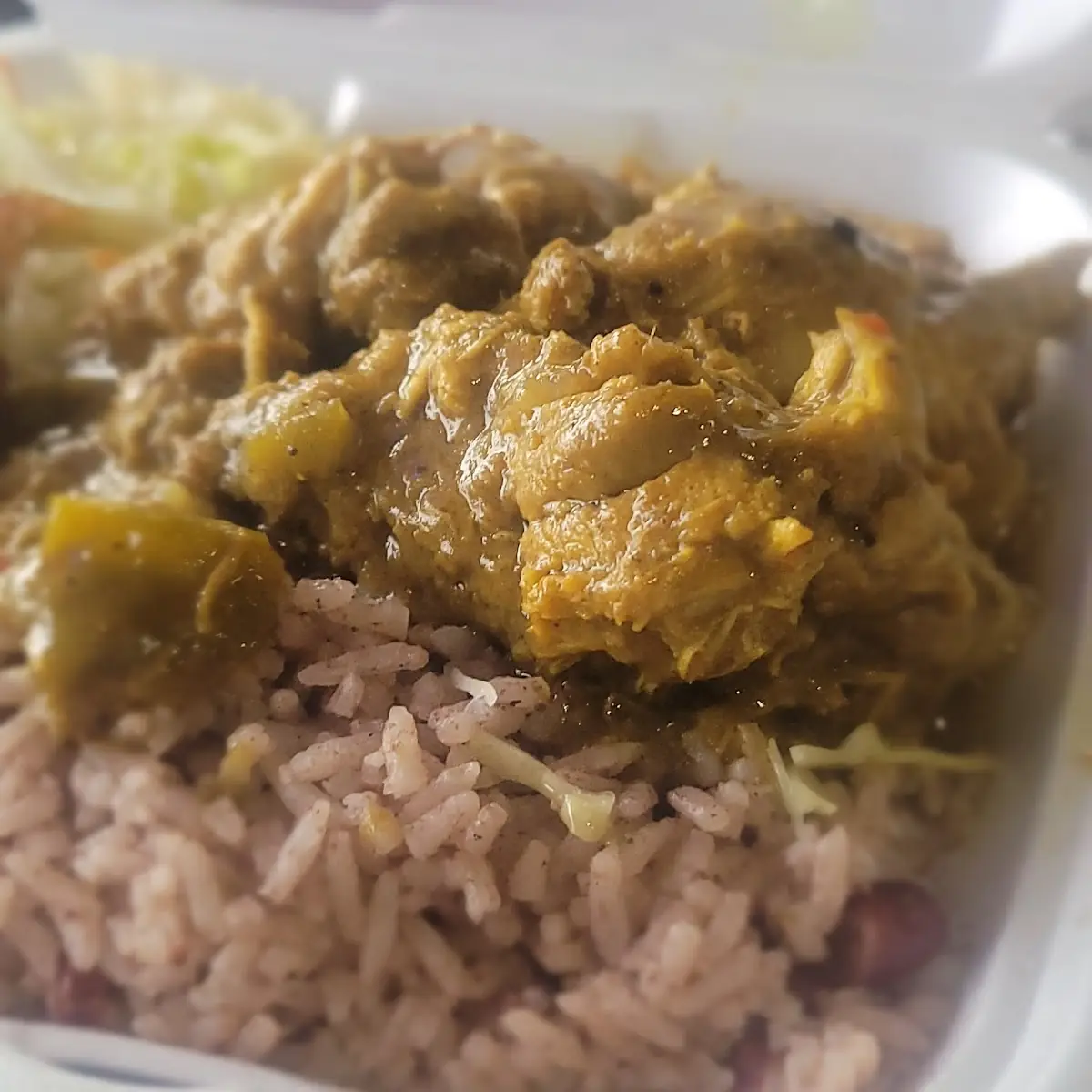 Curry Chicken Served with White Rice and Peas