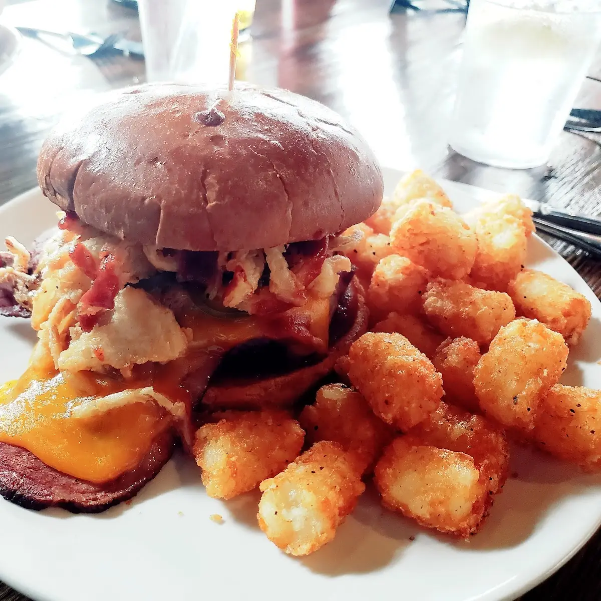 Brisket Sandwich with Jalapenos Crispy Onion Strips Cheddar Cheese and Tator Tots